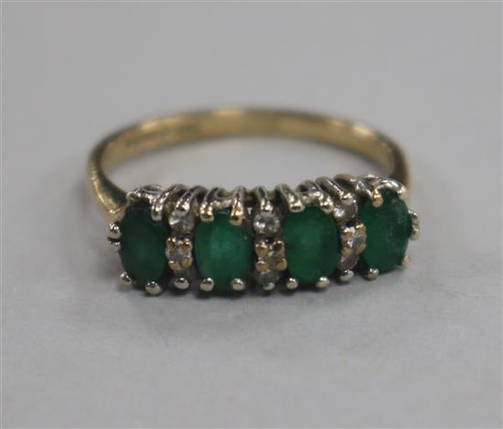 A 9ct gold and emerald half hoop ring, size M.